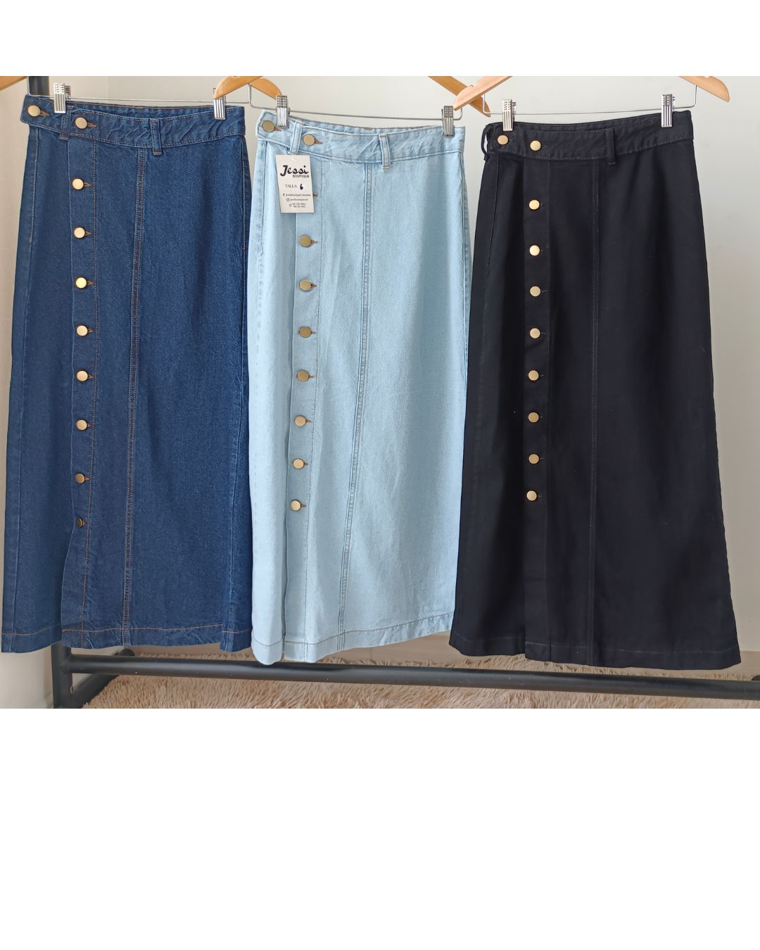 Falda maxi o larga de jeans rígido con botones dorados funcionales y abertura frontal en la pierna. Disponible en azul claro, azul oscuro y negro. Tallas 6 a 16. Jessi Boutique.