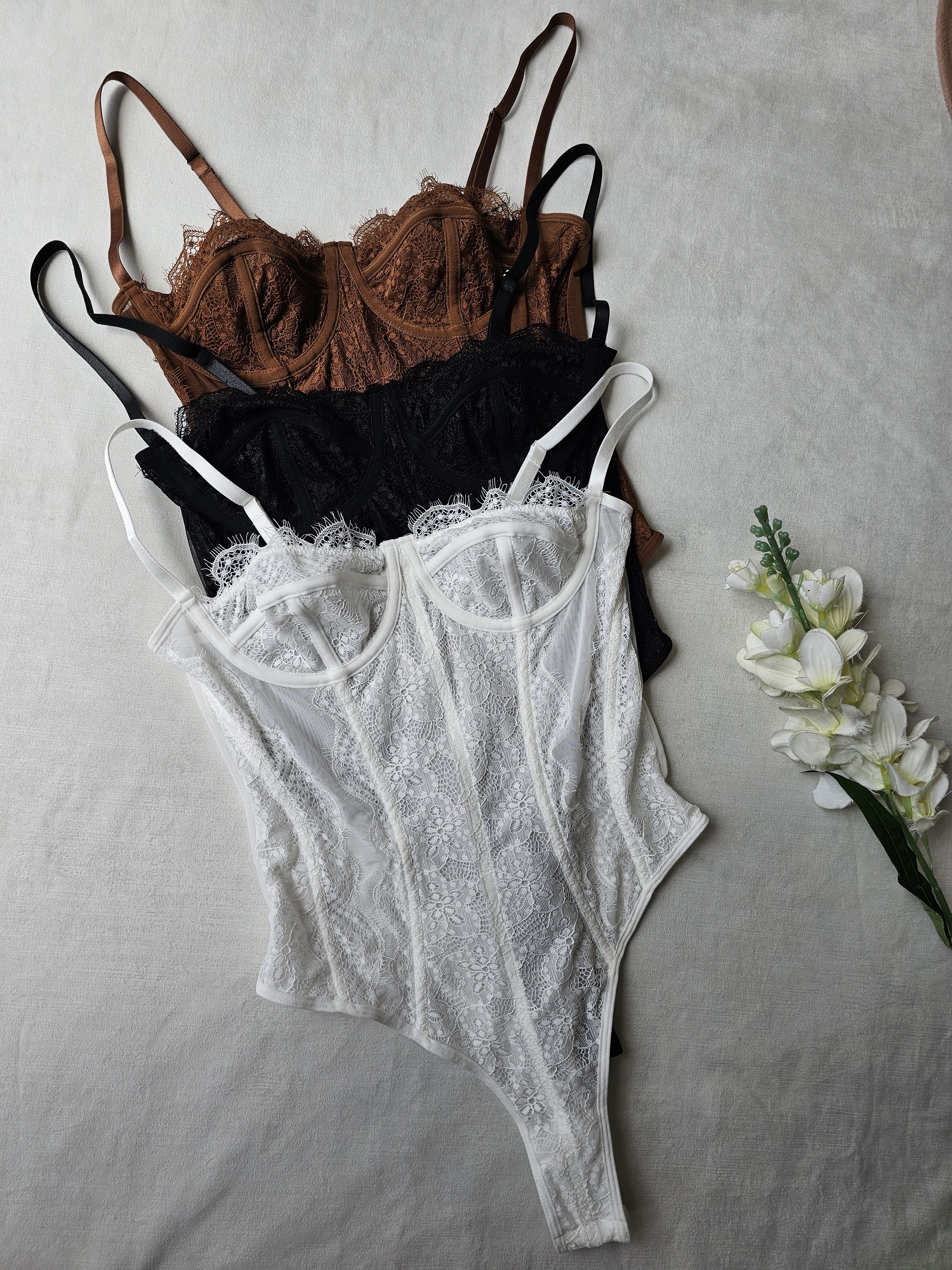 Body tipo corset para mujer en encaje floral con varilla y copas. Body de lencería elegante con tirantes ajustables disponible en blanco, negro y terracota. Prenda sofisticada en tallas S, M, L y XL en Ibagué. Jessi Boutique.