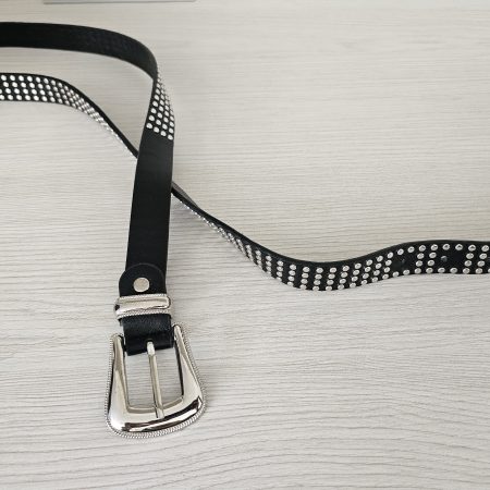 Cinturón negro para mujer con taches plateados y hebilla metálica labrada. Cinturón de cuero sintético estilo rockero para pantalones y faldas. Accesorio con tres filas de tachuelas plateadas. Jessi Boutique.