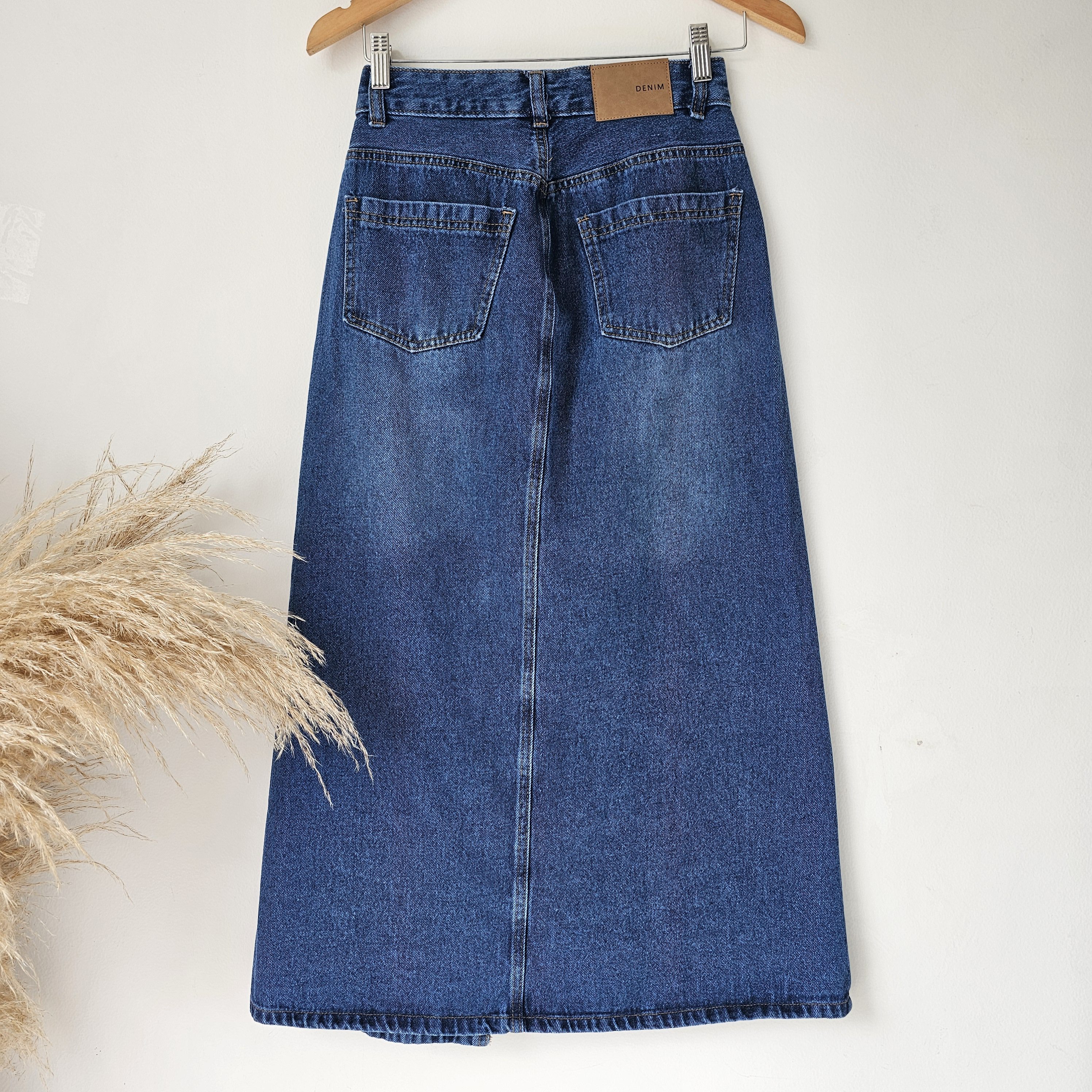 Falda larga de mezclilla para mujer con abertura frontal y bolsillos. Falda denim midi en tono azul oscuro prelavado. Jean rígido de tiro alto. Moda femenina Jessi Boutique.