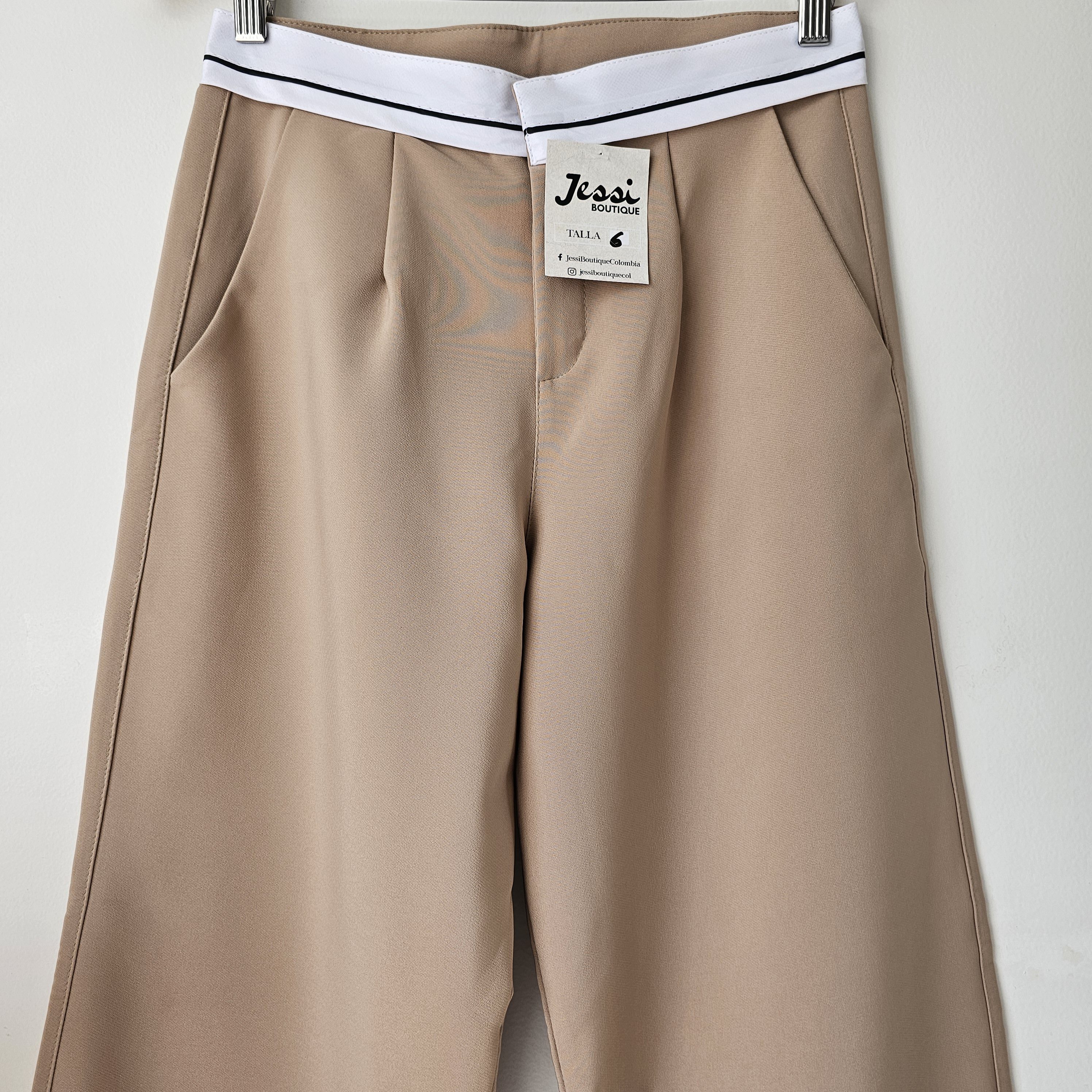 Pantalón sastre para mujer de bota ancha en lino noche de viena. Pantalón de tiro alto con pretina blanca decorativa disponible en color beige, camel y blanco. Moda femenina elegante Jessi Boutique