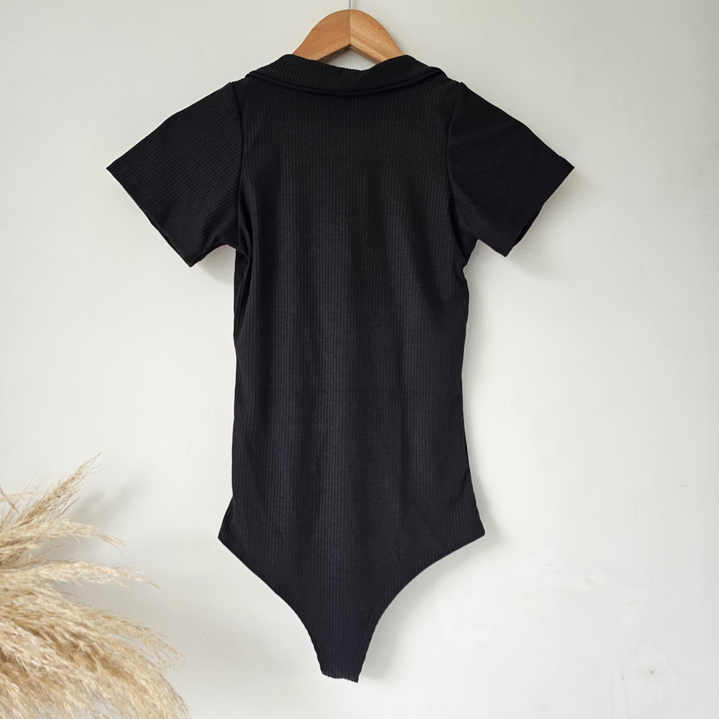 Body para mujer en tejido rip de algodón con cuello polo y cierre de cremallera. Body de manga corta disponible en colores blanco, negro, café, verde menta y beige. Tallas SM y ML. Jessi Boutique.