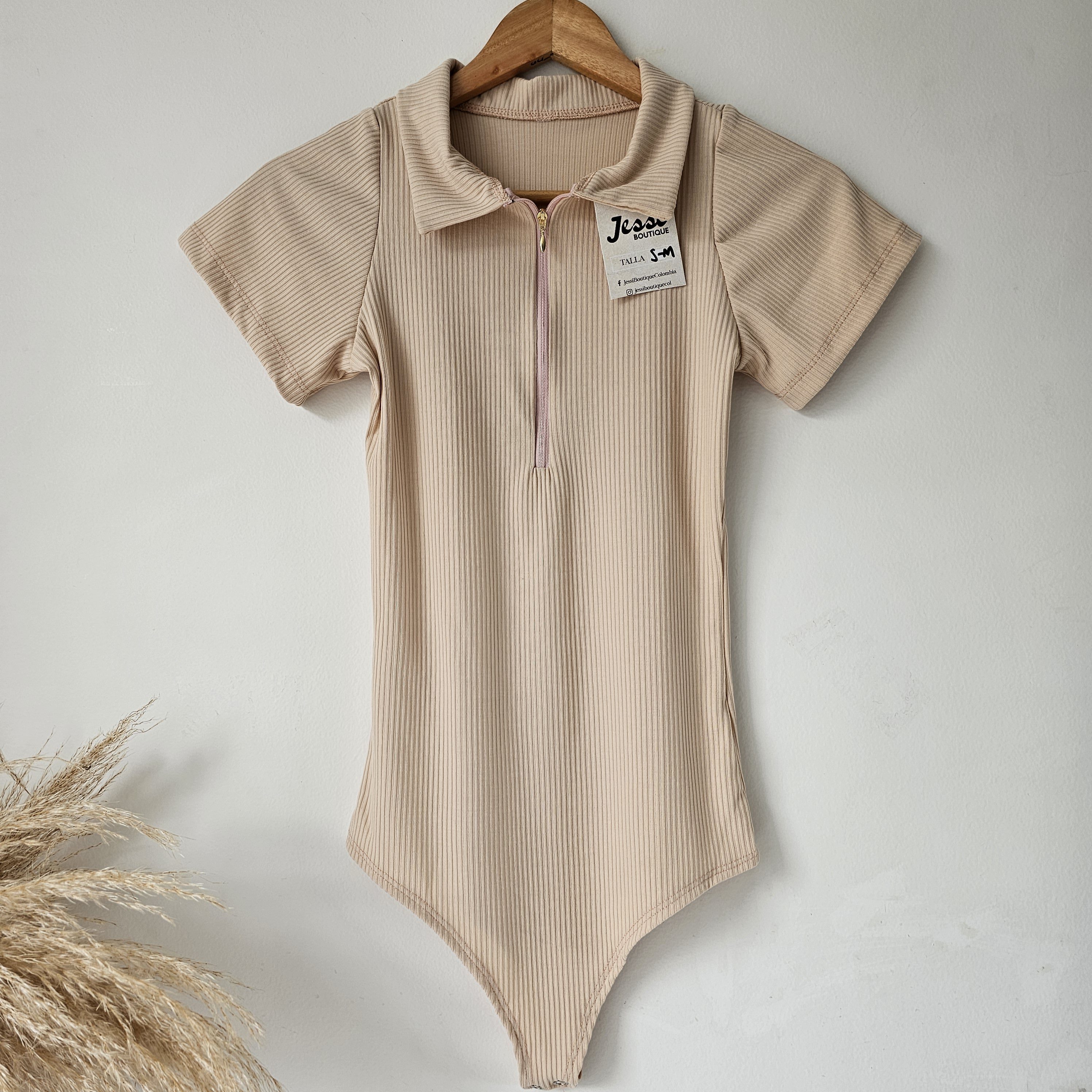 Body para mujer en tejido rip de algodón con cuello polo y cierre de cremallera. Body de manga corta disponible en colores blanco, negro, café, verde menta y beige. Tallas SM y ML. Jessi Boutique.